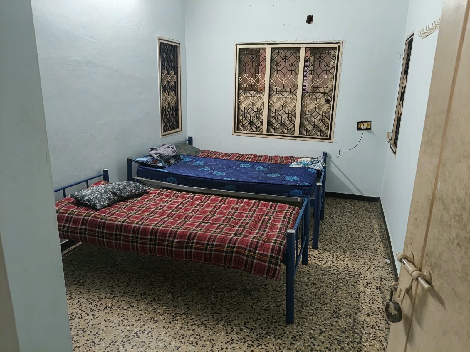 Twin single beds in a men's PG room at Shree Sai Vishnu PG, East Tambaram